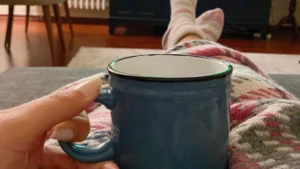 Uma mulher descansando com uma xícara de café.